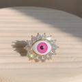 Macro detail of evil eye ring with pink resin iris and sparkling cubic zirconia halo - Adjustable Open / Pink