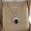 Gros plan du collier abeille argenté avec pierre noire facettée et strass brillants - Abeille