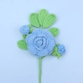 Handcrafted blue crochet sunflower with green leaves and stem on a light blue backdrop - Finished Camellia Bouquet (blue)