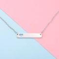 Macro shot of silver bar necklace pendant with hollow heart detail on split pastel background - 16" / Steel