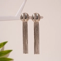 Dettaglio di orecchini pendenti con nappe argentate su un supporto decorativo bianco - Perno in argento - Orecchini con nappe argentate