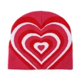 Close-up of pink knit beanie featuring layered red and white heart patterns on the fabric - Rose Red