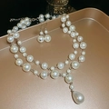 Detailed view of teardrop pearl double necklace and matching earrings on tray - 2-Piece Set White Pearl Ear Hook Necklace & Earrings