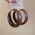 Detalle de pendientes de aro en cuero marrón oscuro con pasador dorado y costuras - Café Oscuro