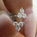 Macro shot of silver stud earrings featuring a three-stone cluster triangle design - White Gold