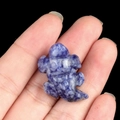 Mini blue and white marbled stone animal carving held between fingers for scale - Blue Spot Stone