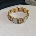 Detail von ovalen Vintage-Gold-Kreuzanhängern und silbernem Glitzer auf dem Armband - Kreuz-Ellipse-Spleiß-Stil / Antikgold mit Silberschimmer