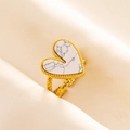 Macro shot of gold heart ring with marble stone inset on beige silk fabric background - Gold Tone-White Marble Look (J549-G-W)