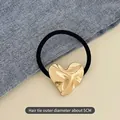 Elastic hair tie with a 5cm golden irregular heart pendant and black high-stretch cord - Embossed Hearts