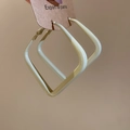 Close-up of geometric square hoop earrings in cream beige finish on a display card - Cream White