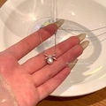 Dettaglio del ciondolo a fiocco a cuore con micro-diamanti e perla tonda bianca - Argento (Perla Fiocco Strass)