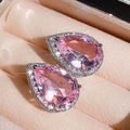Macro shot of pear-shaped pink zircon earrings with halo diamond setting on velvet - Pink