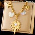 Dettaglio di una collana placcata oro con ciondoli a sole, uccello e cuore su portagioie - Stile Fascino Cuore Uccello Sole (N3215)
