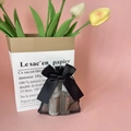 Elegant black organza gift bag with ribbon bow holding two small cosmetic bottles - Black