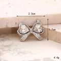 Detailed macro view of a silver bow-shaped zinc alloy charm with heart gemstones - Double Heart Small Tie White
