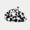 Detailed close-up of soft faux fur beret featuring a trendy black and white cow print texture - One Size / Leopard White