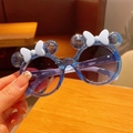 Detail of blue glitter kids round sunglasses featuring cartoon ears and a white bow decoration - Blue