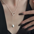 Elegante silberne Halskette mit hohlem Ring und Perlenanhänger an weiblichem Modell - Hohlring Silberperlen Halskette