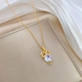 Lujoso collar de lazo dorado con colgante de circón brillante sobre fondo de seda blanca - Estilo de Lazo Dorado