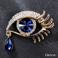 Golden eye-shaped brooch with blue teardrop crystal and rhinestones, size 3.8x5cm - Angel's Tear