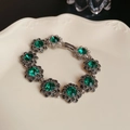 Detailed shot of silver bracelet with green gemstone flower on a ceramic plate - 9# Bracelet-Green-Flower