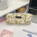 Gros plan sur la trousse en velours côtelé fleuri avec fermeture éclair dorée et étiquette - Petites Fleurs Vertes