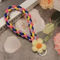 Close-up of a handmade four-color braided phone lanyard with a knitted yellow flower detail - Yellow Blue Pink Purple/Yellow Flower