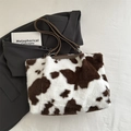 Faux fur tote bag featuring a brown and white cow print with brown leather straps - Brown
