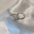 Close-up of polished silver hoop earrings resting on elegant white silk fabric - Minimalist Hoop (E5209 Silver)