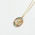 Detailed close-up of a gold oval Virgin Mary pendant with multi-colored gemstone inlay - Multicolor Zirconia Guadalupe / Gold Multicolor Zirconia