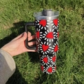 40oz stainless steel insulated tumbler with red heart patterns held over grass - A3 / Red Heart Stripes