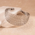 Detail eines silbernen, welligen, mehrlagigen Armreifens auf einem Naturstein - Bangle / Silber