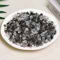 Black and white natural tumbled quartz crystal stones presented on a white round ceramic plate - Black Rutilated Quartz (7-9mm) 100g