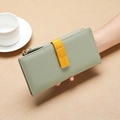 Green long PU leather wallet with yellow contrast strap held by a model with a coffee cup - Green