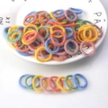 Dettaglio di elastici per capelli in peluche morbido in vari colori vivaci su un piatto - Linea di Peluche di Colore Caldo 100 Pezzi