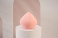Pink teardrop makeup sponge on a white pedestal for flawless dry and wet cosmetics use - Pink Waterdrop