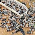 Detailed macro view of 8mm marble pattern ceramic beads on a rustic fabric background - Black Gold (Painted 6x12mm)