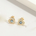 Detailed close-up of gold heart stud earrings featuring evil eye motif and crystals - Royal Blue Heart