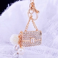 Exquisite gold keychain featuring a rhinestone mini bag, white rose, and large pearl - White Pearl Handbag