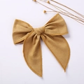 Detail of mustard yellow linen fabric bow hair clip for girls with natural texture - Earthy Yellow