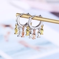 Macro shot of silver, gold, and rose gold fish charm earrings with black zircon eyes - Three-Color Fish Ear Buckle