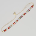 Détail d'un bracelet tissé main avec perles céramiques rouges, dorées, bleues et cordon - Rouge Or Gris-Bleu Tissé