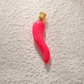 Pink enamel chili pepper pendant with gold plated ring on a textured background - Rose Red