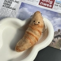 Handmade wool felt croissant keychain with smiling face in a ceramic dish - Croissant