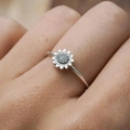 Macro shot of silver sunflower ring with detailed petals and textured center on finger - US 5 / White Gold