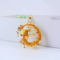 Llavero de dragón dorado con gemas rojas y amarillas y perla blanca en fondo minimalista - Dorado
