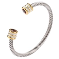 Detailed shot of twisted steel cuff bracelet featuring red gemstones and gold accents - July (Ruby Red)