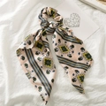 Detailed close-up of pink satin hair scrunchie with geometric patterns and blue stripes - Pink Square Floral