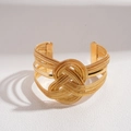 Detail eines goldenen geflochtenen Armreifs mit einem großen konzentrischen Knoten - Gold