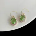 Boucles d'oreilles dorées avec pierre ovale verte et halo de zircons blancs - Zircon Vert Ovale Rétro
